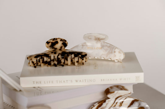 Two hair clips on a book with a plain background