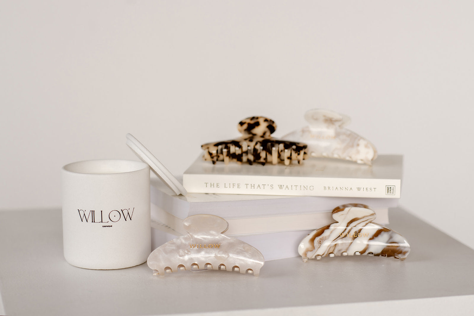 Candle labeled 'Willow' with decorative items on a shelf